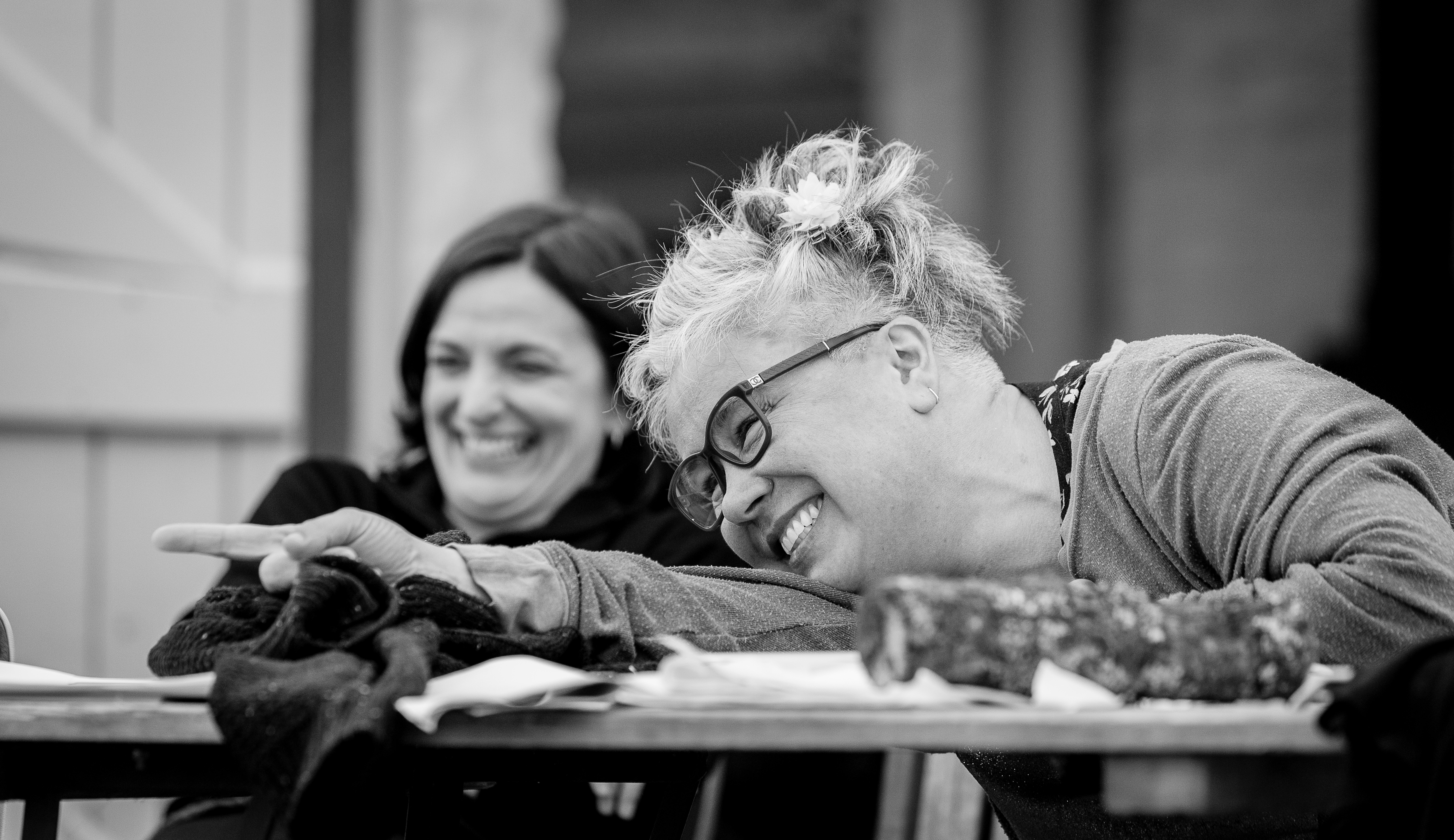 Two women laughing and having a conversation at a table.