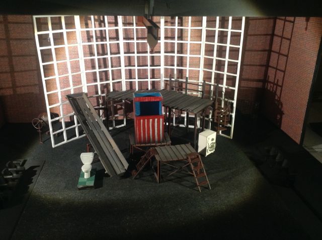 A model of a stage with a table and chairs.