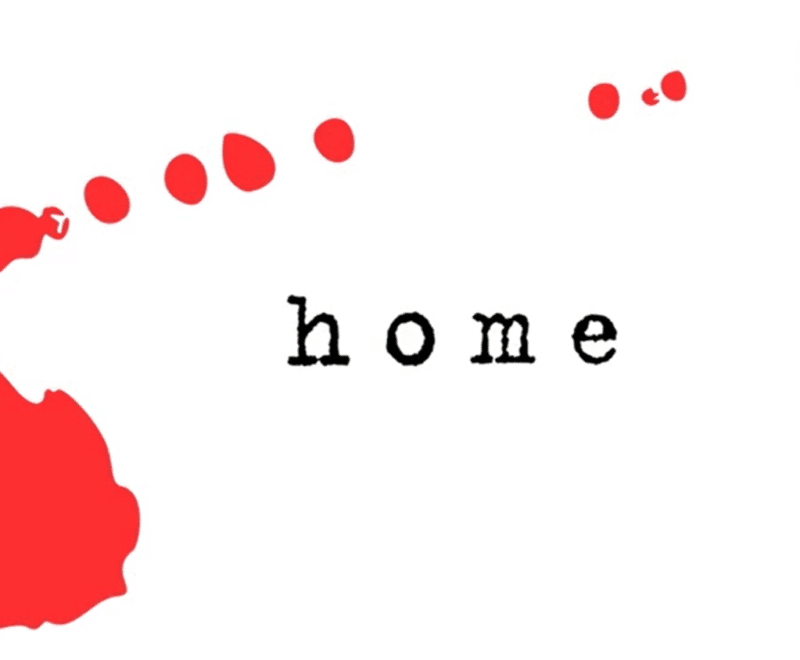 The word 'Home' in lowercase black typewriter style font is centered in the image. A red mark, as if a splash of ink,