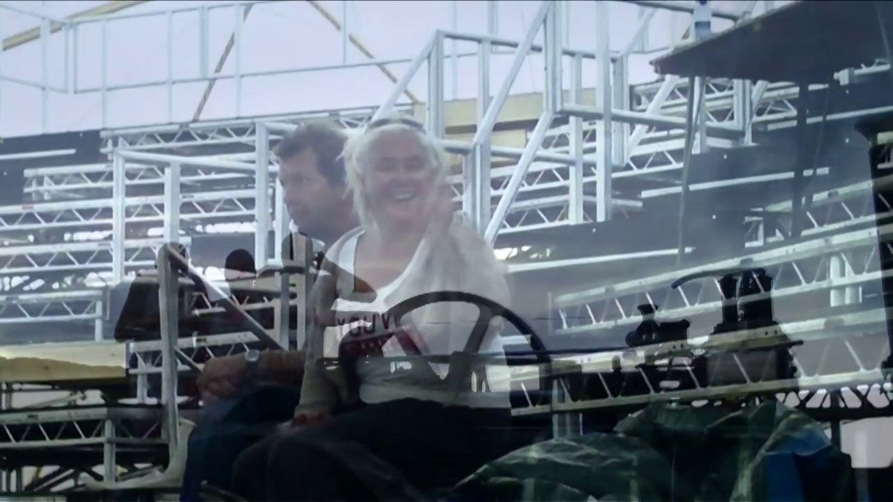A man and a woman sitting on bleachers.