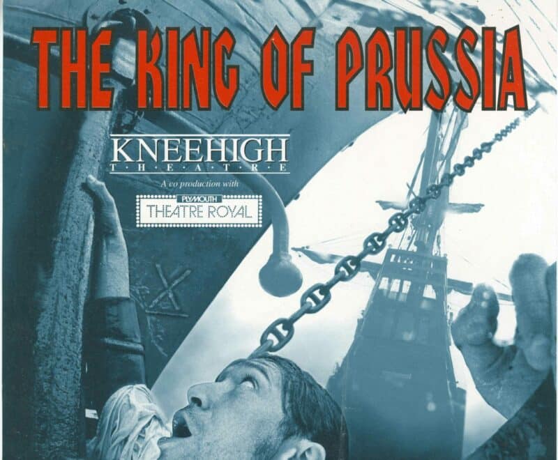 Poster for Kneehigh's production of Nick Darke's The King of Prussia. Featured a photograph of the upper body and face of a man in the sea alongside the hull of a tall ship, presented in blue and grey tones. Accompanying text is in red including the quote 'if the law's unjust...break it'.