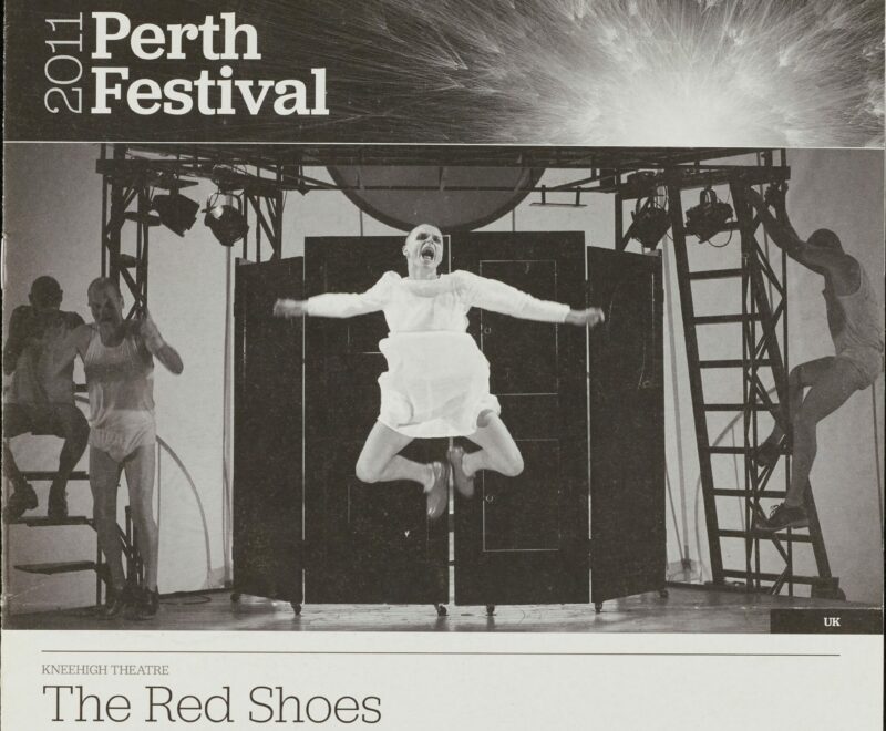 Image features a black and white production photograph in the centre of an white backdrop. The photograph features a female performer in a white dress and red shoes jumping in a state of excitement on stage. There is a banner above the image featuring an image of a firework exploding and text reading '2011 Perth Festival'. There is a range of written content beneath the image including the production title 'Red Shoes' in a thin black text and performance details and cast in a smaller black text.