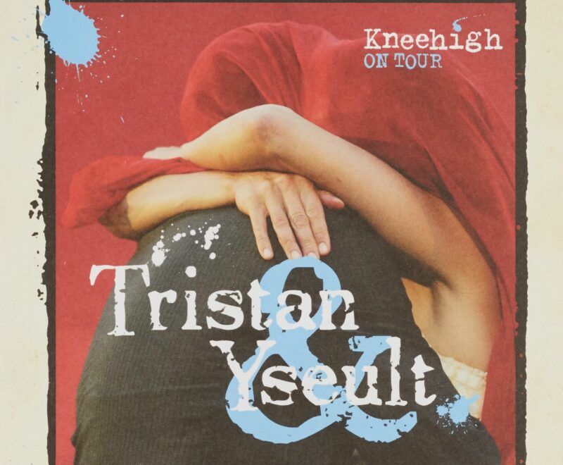 Features an image of two individuals embracing with a red blanket covering their heads. The image is set against a red backdrop and features the production title 'Tristan and Yseult' in a large white and blue font resembling paint splatter.